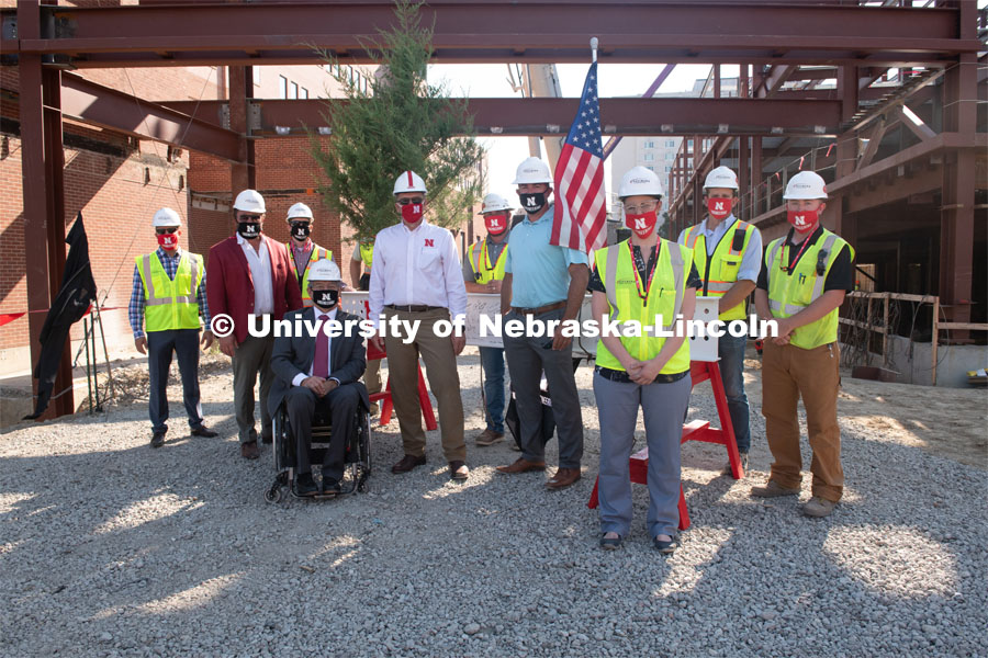 Left to right Joey Hausmann, Lance Perez, Chancellor Ronnie Green and Chad Wiles pose with the workers and the final beam. Due to COVID-19 precautions, a public ceremony was not able to be held. Instead, signatures from college and university supporters and others involved in the Phase I project were gathered either remotely or by signing the beam individually. The final beam was installed at the topping off ceremony for Engineering Project, August 26, 2020. Photo by Greg Nathan / University Communication.